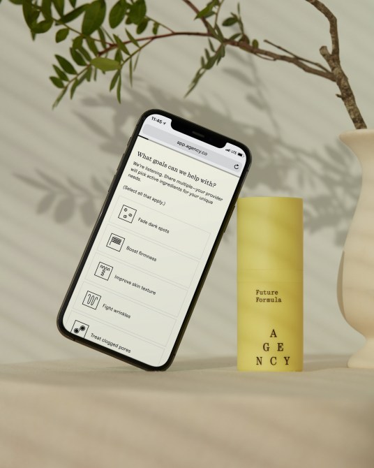 Agency Future Formula bottle with phone with the Agency app opened