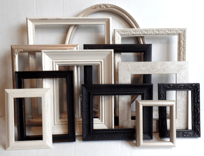 Layers of mismatched frames propped up on a wall