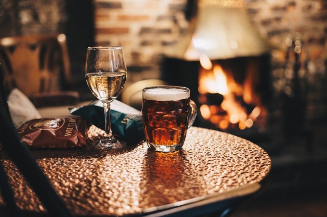 Two drinks in front of a fireplace