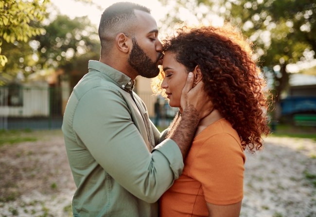 Shot of a young man giving his girlfriend a kiss on the forehead outdoors