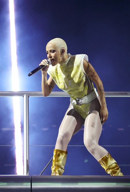 Doja Cat wearing a belted bodysuit and gold boots.