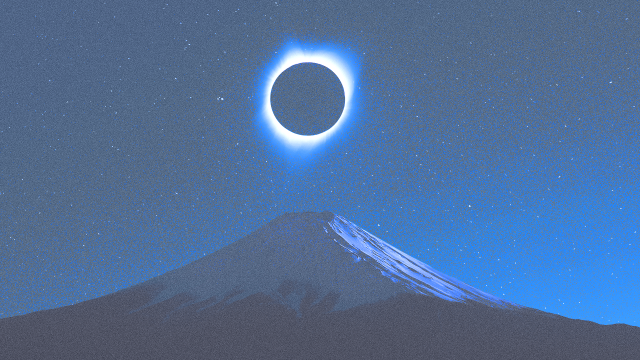 StyleCaster | A total solar eclipse rising above mountain across a deep blue night time sky