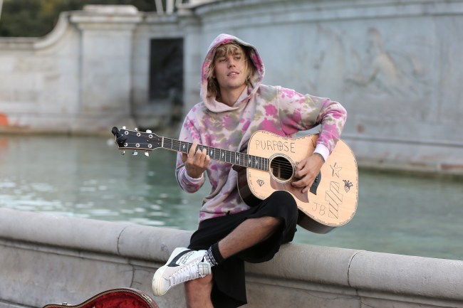 Justin Bieber stops at the Buckingham Palace fountain to play a couple of songs with his guitar for Hailey Baldwin and fans on September 18, 2018 in London, England.