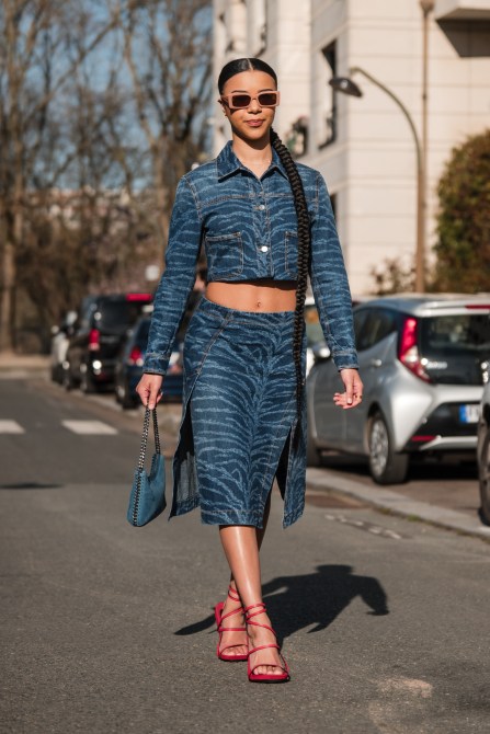 Woman wears denim zebra print crop jacket with matching midi skirt, blue Stella McCartney bag, red heels, nude sunglasses, outside Stella McCartney,