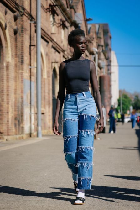 SYDNEY, AUSTRALIA - MAY 14: A guest wearing jeans and black tank during Australian Fashion Week Presented By Pandora 2024 at Carriageworks on May 14, 2024 in Sydney, Australia.