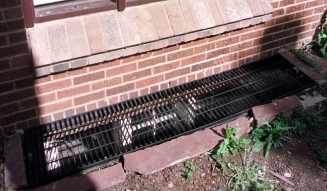 A grate covers a basement window at the Ramsey house where JonBenét Ramsey was killed