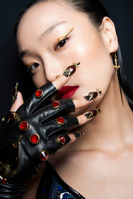A model with black nails and heart charms.