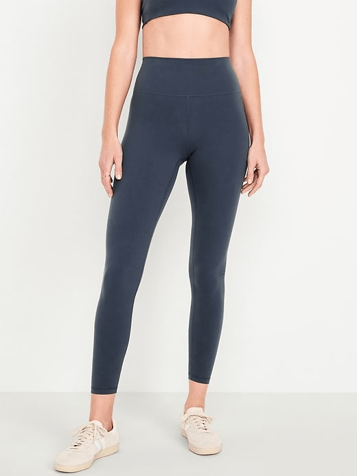 A model wearing the Old Navy High-Waisted StudioSmooth 7/8 Leggings in Dusk Navy colorway