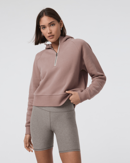 A model wearing the Vuori Restore Half Zip Hoodie in Canyon Clay colorway