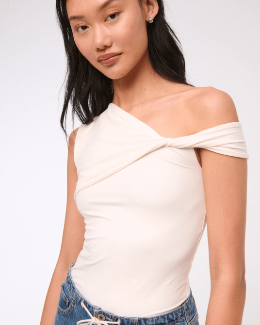A model wearing the Abercrombie & Fitch Soft Matte Seamless Asymmetrical Twist Top in white