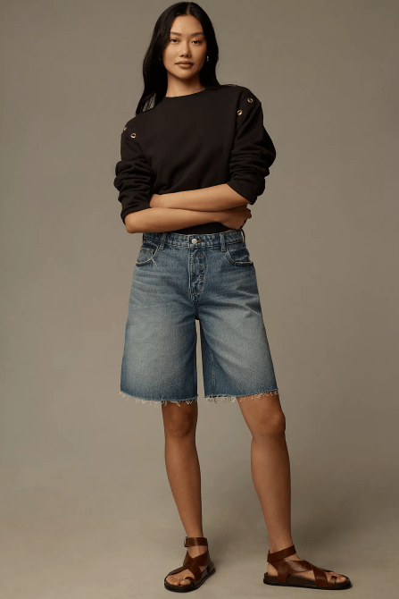 A model wearing the Pilcro Classic Bermuda Denim Shorts in a medium denim wash