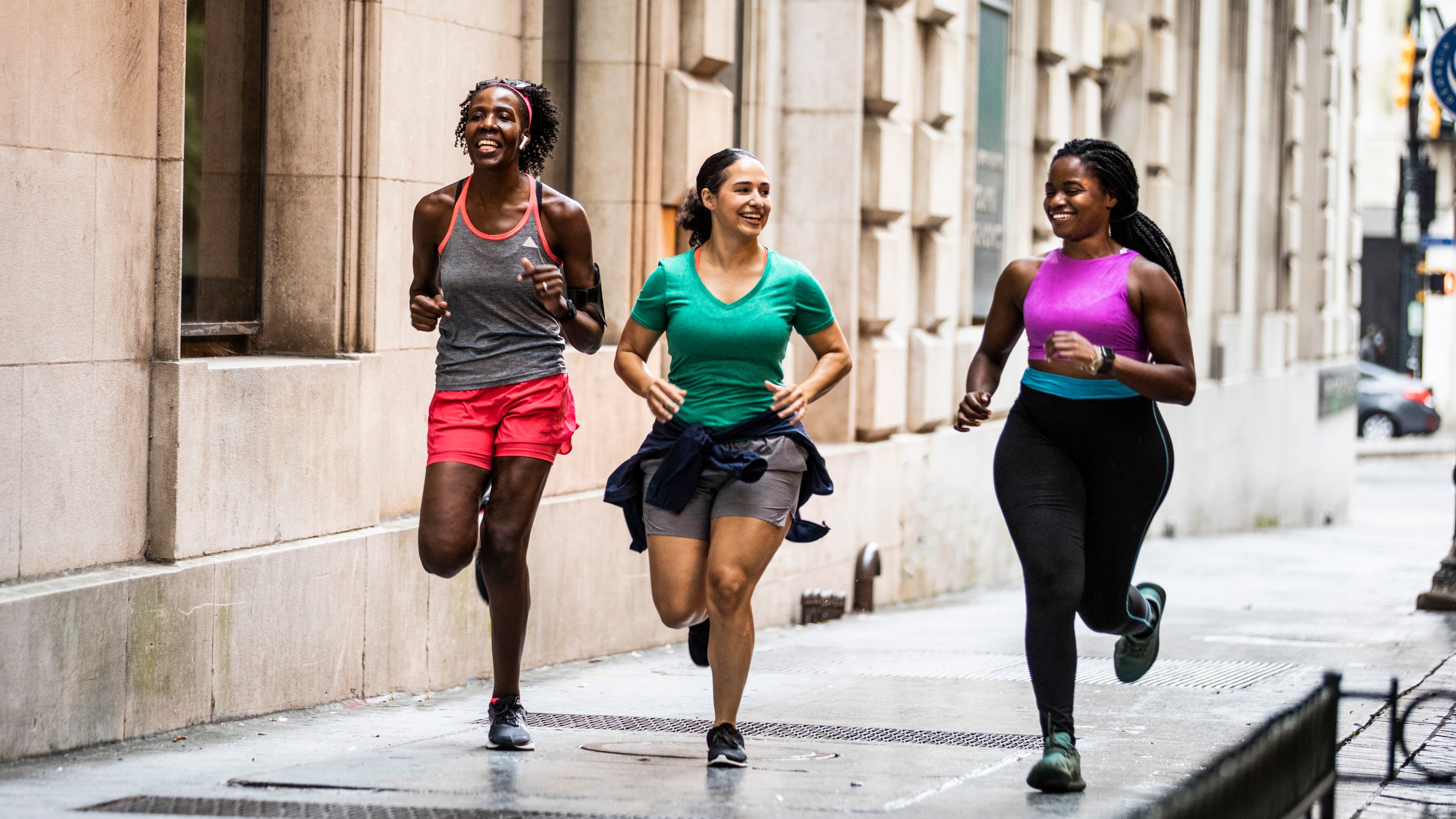 Group of women running through urban area