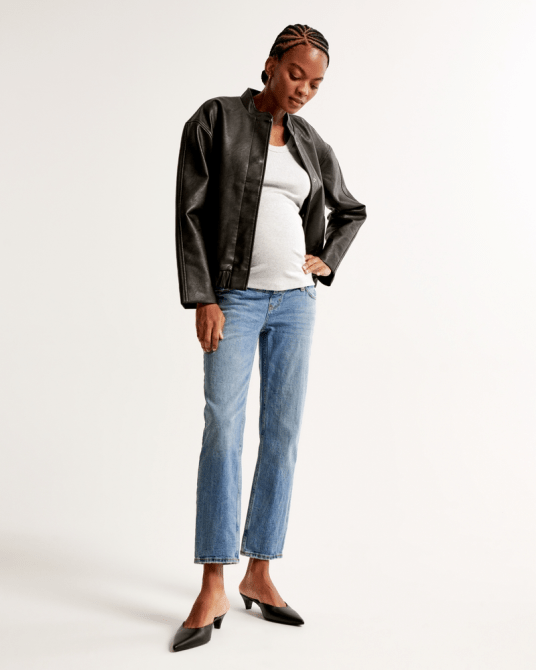 A model wearing Abercrombie & Fitch's Maternity Ankle Straight Jean in a medium wash