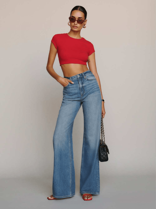 A model wearing Reformation's Cary Lived-in Wide Leg Jeans in a medium wash