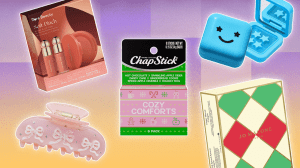 Left to Right: a Rare Beauty gift set box, a light pink Emi Jay claw clip with three bows on it; a ChapStick holiday gift set box; a blue Starface pimple patch holder; a Jo Malone London holiday gift set box