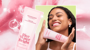 A pink background with a photo of a woman holding a cleanser bottle and smiling.
