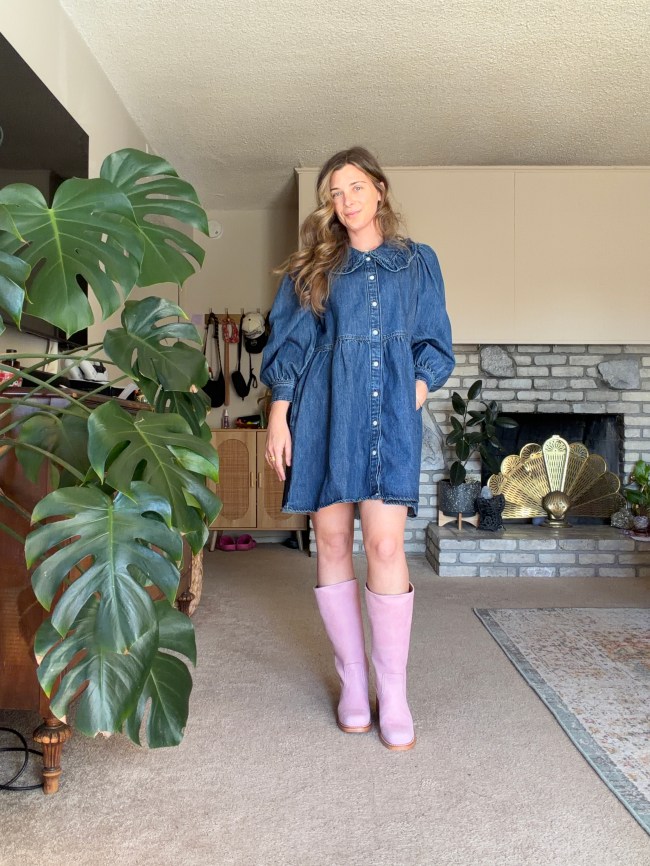 Woman in a blue denim dress and pink Frye boots.